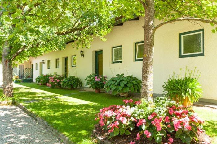 a house with flowers in front of it at Ferienwohnungen Kärnten Dr. Baumgartner in Faak am See