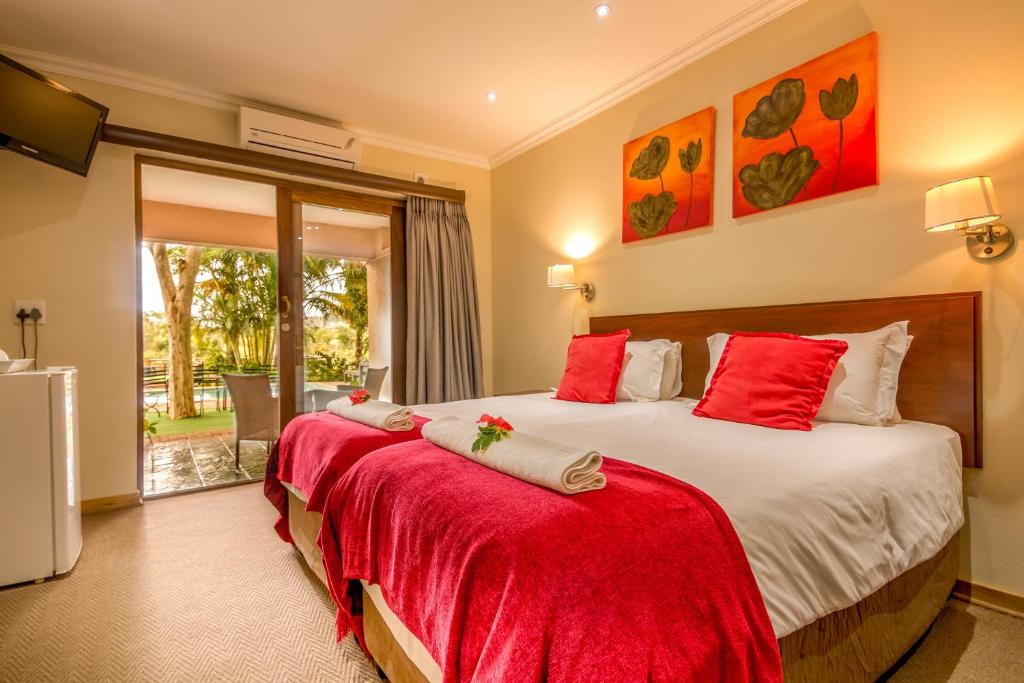 マレラネにあるRio Vista Lodgeのベッドルーム1室(赤い枕のベッド2台付)