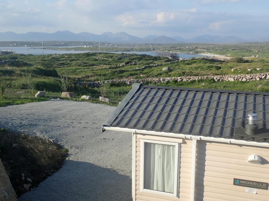 una piccola casa con finestra su una strada sterrata di Earls View Caravan a Carna
