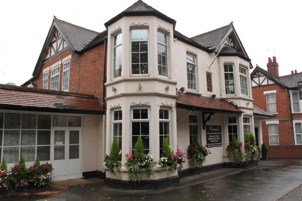 a white building with flowers in front of it at Abbey Grange Hotel in Nuneaton