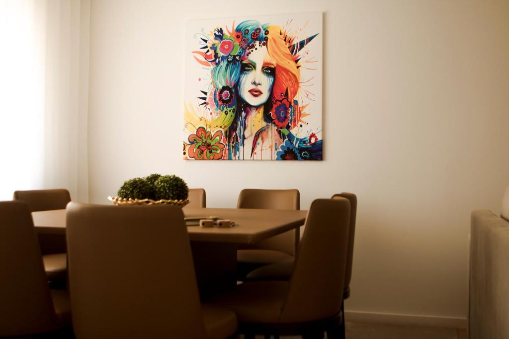 a dining room table with a painting of a woman at Nightingale Apartments in Porto