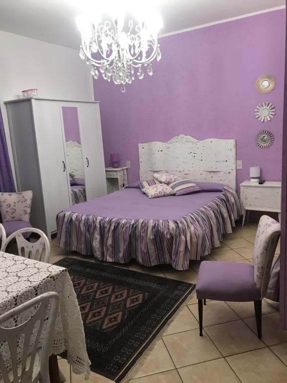 a purple bedroom with a bed and a chandelier at Stella Polare B&B in Rieti