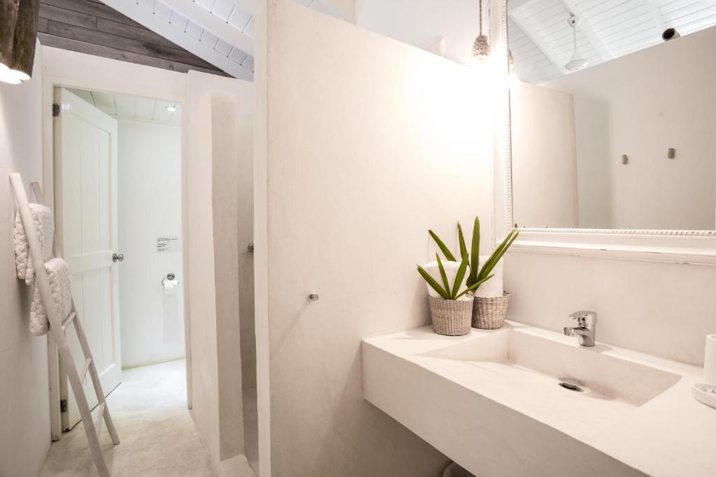 a white bathroom with a sink and a mirror at Mahona Boutique Hotel in Las Terrenas