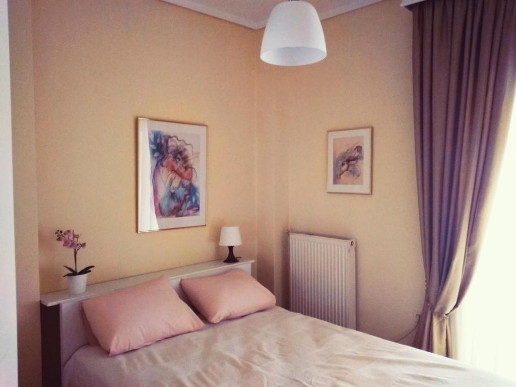 ネオイ・エピヴァタイにあるRozy House Nei Epivates Thessaloniki ( Near the sea)のベッドルーム1室(ピンクの枕付きのベッド1台付)
