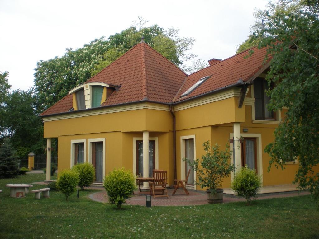 una casa amarilla con techo rojo en Anonim Vendégház, en Villány