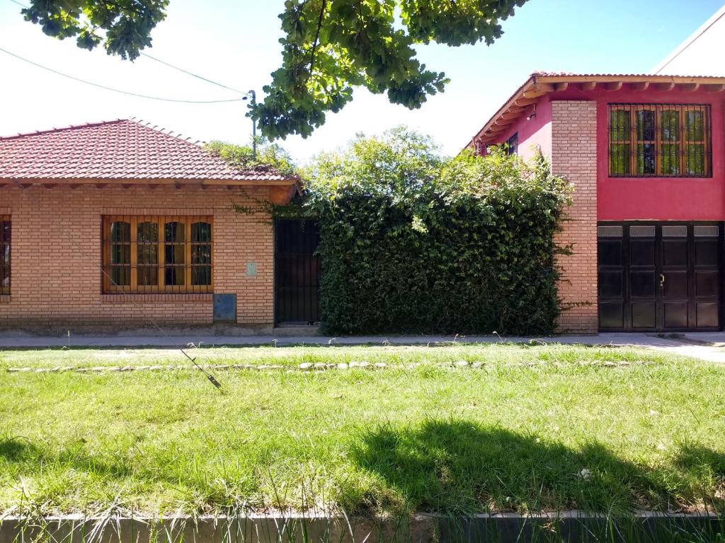 una casa con un patio de hierba delante de ella en Departamento Los Sauces en San Rafael