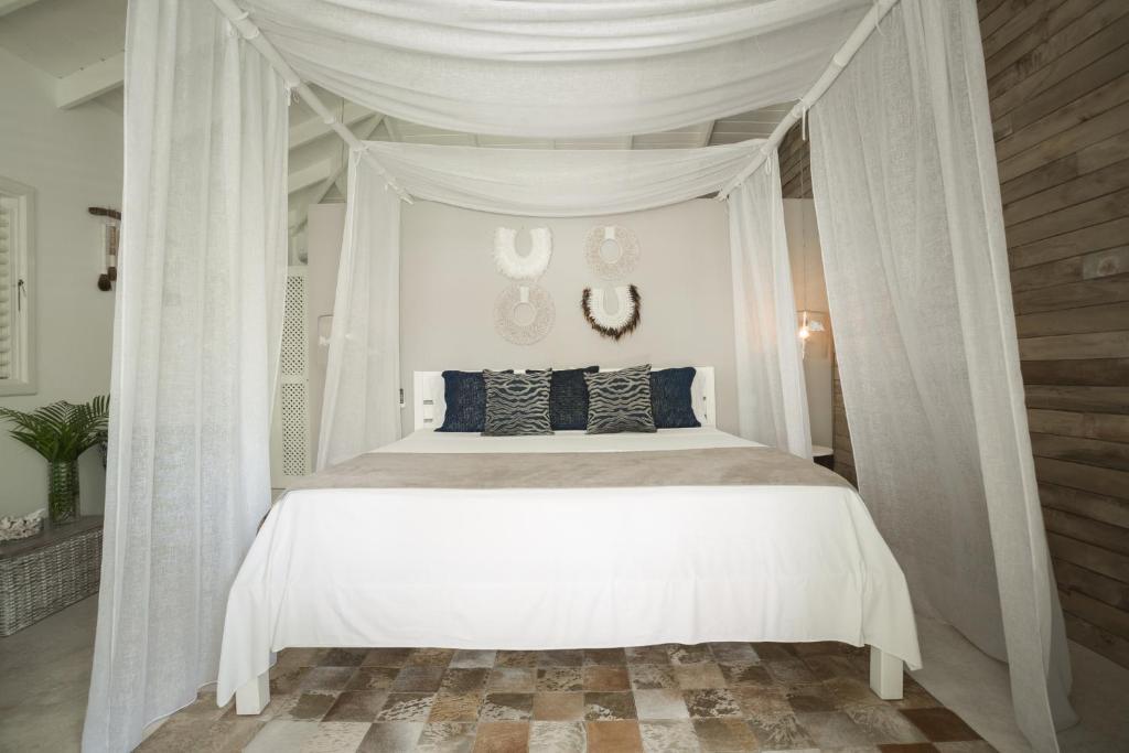 a white bed with a canopy in a bedroom at Mahona Boutique Hotel in Las Terrenas