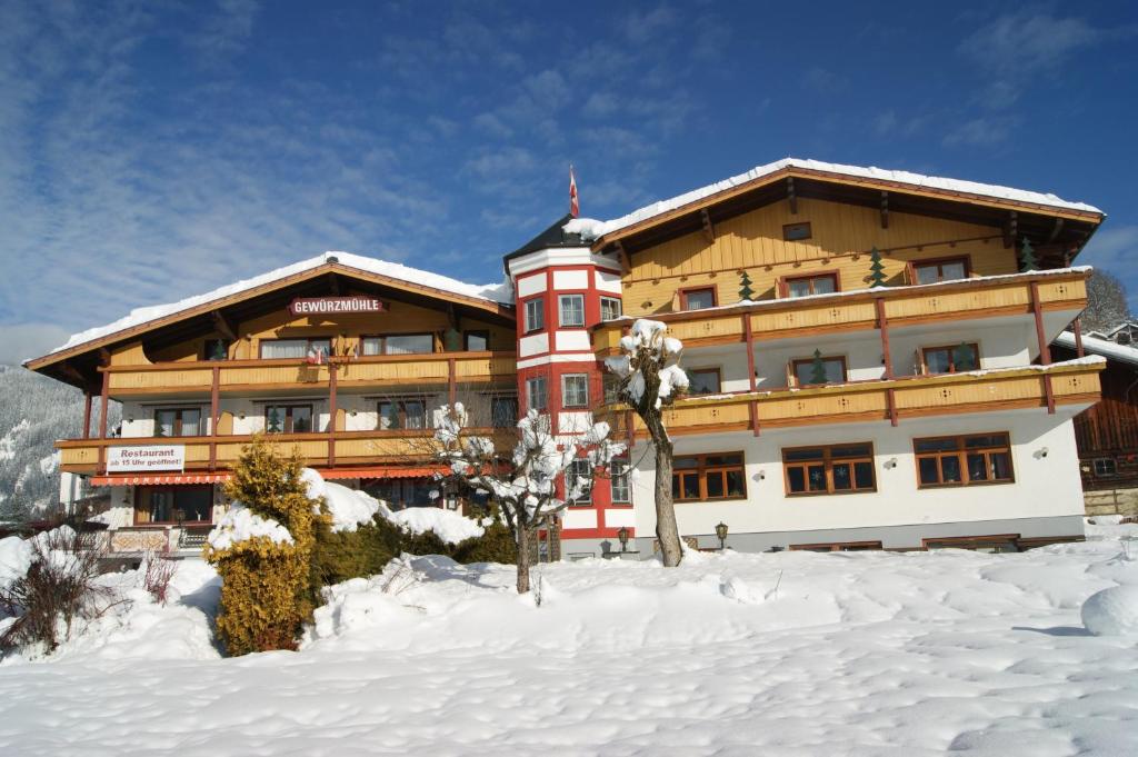 a large building with snow in front of it at Ferienhotel Gewürzmühle in Radstadt