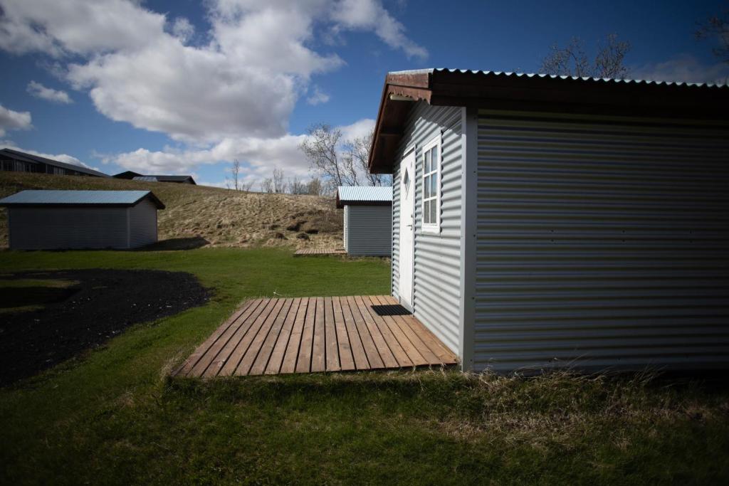 een klein gebouw met een houten terras in een tuin bij Efri-Vík Bungalows in Kirkjubæjarklaustur