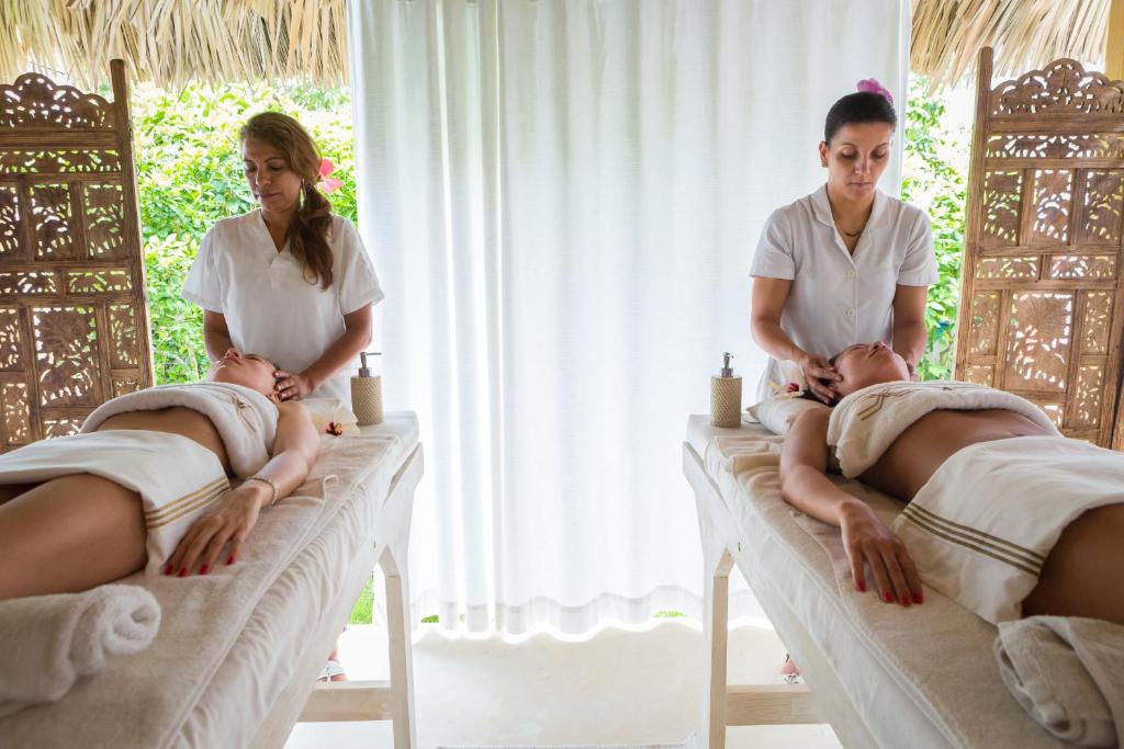 two women sitting on beds in a room at Mahona Boutique Hotel in Las Terrenas