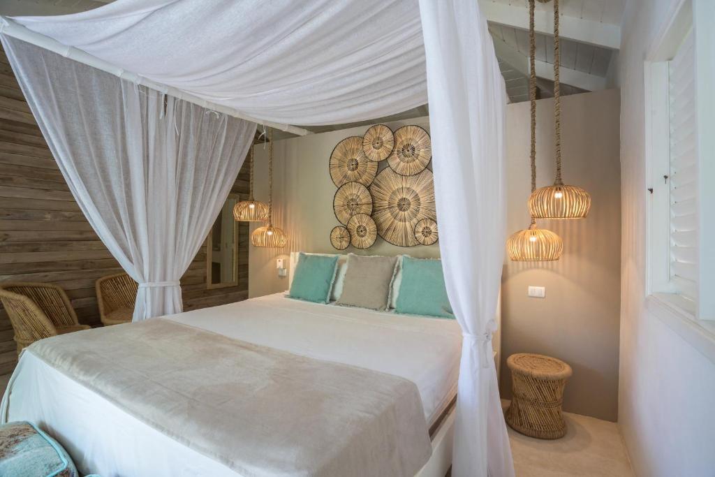 a bedroom with a white bed with a canopy at Mahona Boutique Hotel in Las Terrenas
