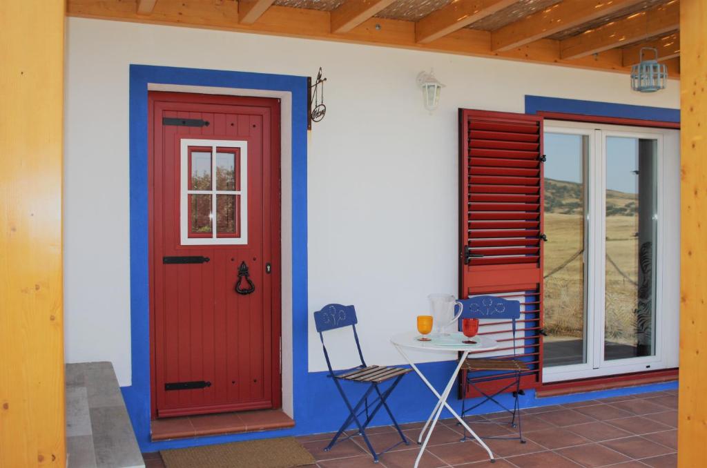 メルトラにあるCasa dos Corvosの赤い扉とテーブルのある家