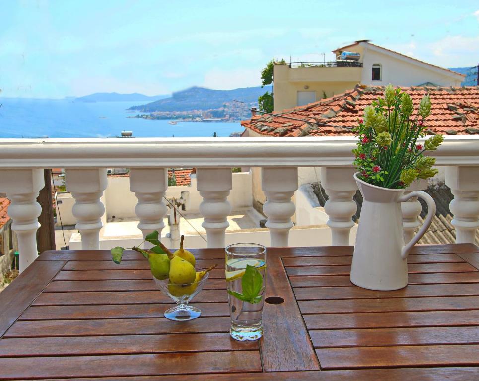 a wooden table with two glasses and a vase on a balcony at Giannis Apartment in Kavala