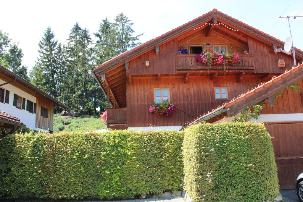 una casa de madera con un balcón con flores. en Ferienwohnung Uschi Willibald, en Wackersberg