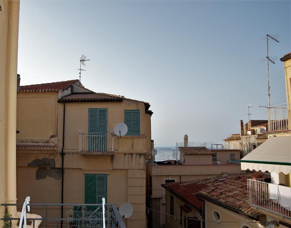 a view of roofs of buildings with the ocean in the background at B&B The Tower in Tropea