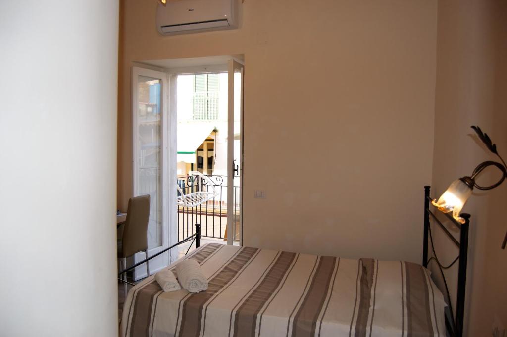 a small bedroom with a bed and a balcony at B&B The Tower in Tropea