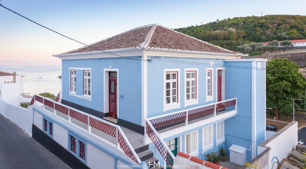 a blue house with a view of the ocean at Casa da Muralha in Angra do Heroísmo