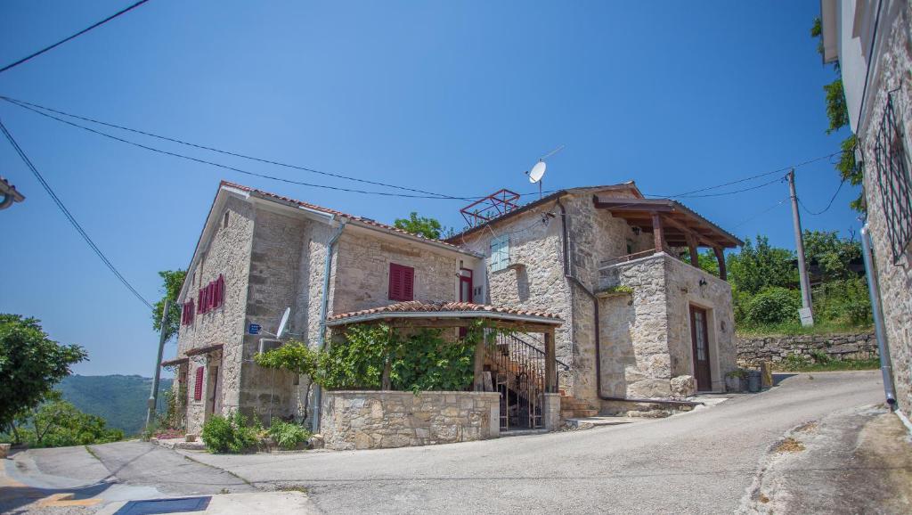 an old stone house on a hill with a street at Apartment Romy for 2-4 people with jacuzzi in Motovun