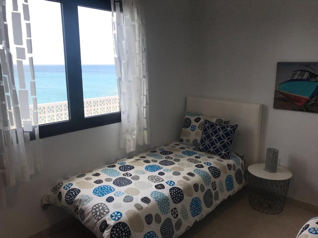 A bed or beds in a room at El Roquito Ocean View