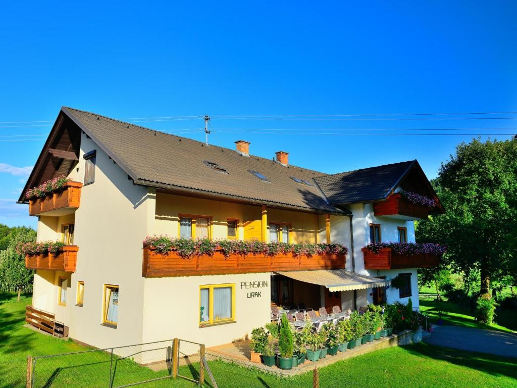 ein Haus mit Blumen auf der Seite in der Unterkunft Erlebnisbauernhof Urak in Sankt Kanzian am Klopeiner See