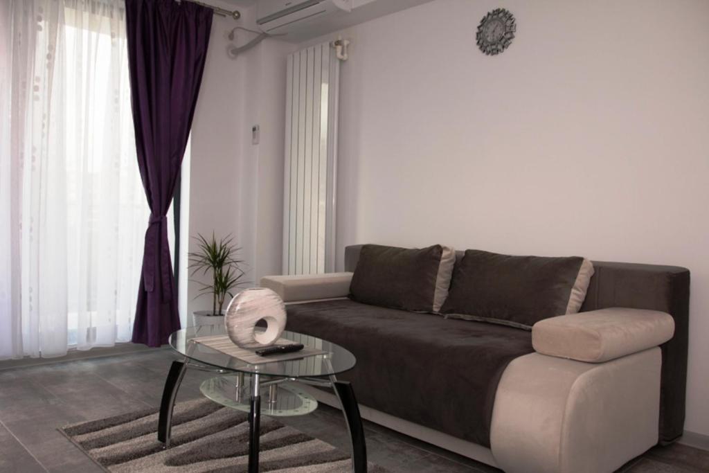 a living room with a couch and a table at Apartament Serenity Mamaia Nord in Mamaia Sat/Năvodari