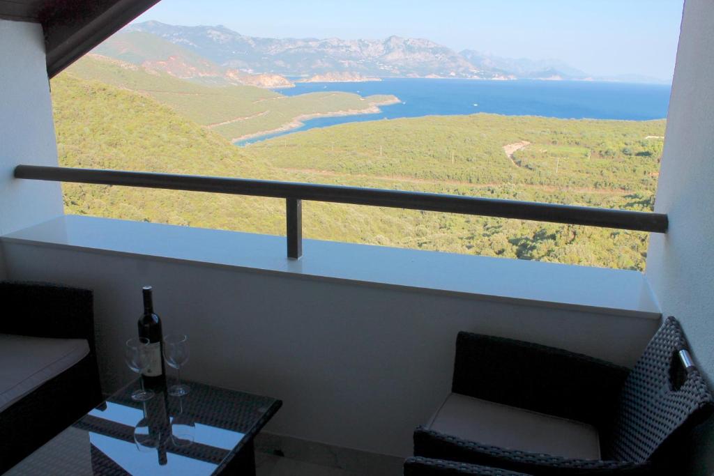 a room with a balcony with a chair and a table at Apartments Villa Milna 1 in Budva