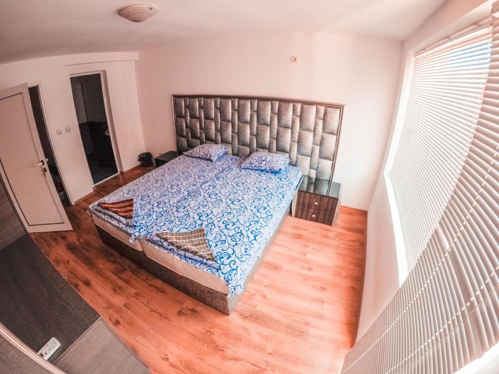 a bedroom with a large bed with a wooden floor at Guest House Gabriel in Sozopol