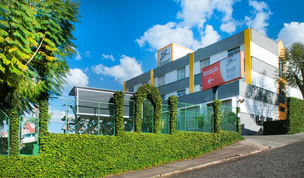 a building with a hedge in front of it at Brivali Hotel Centro in Caçador