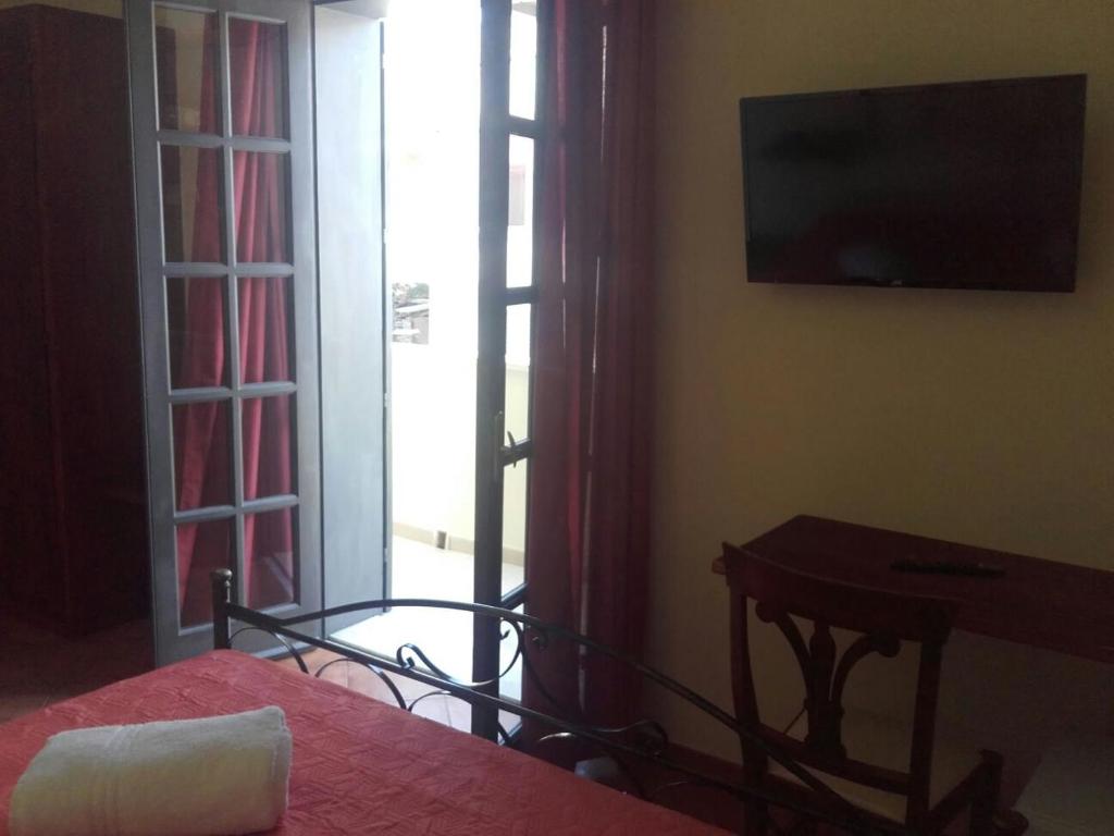 una camera con letto, televisore e tavolo di Guest House Capitan Libeccio a Tropea