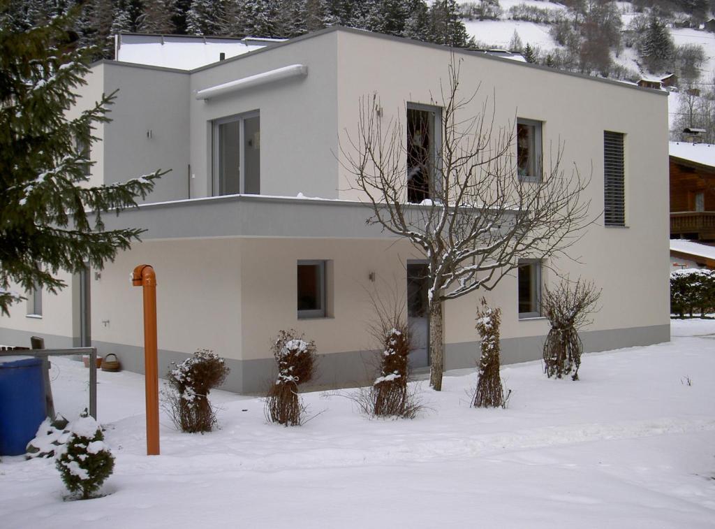 a white house in the snow with trees at Appartement Christopherus in Pettneu am Arlberg