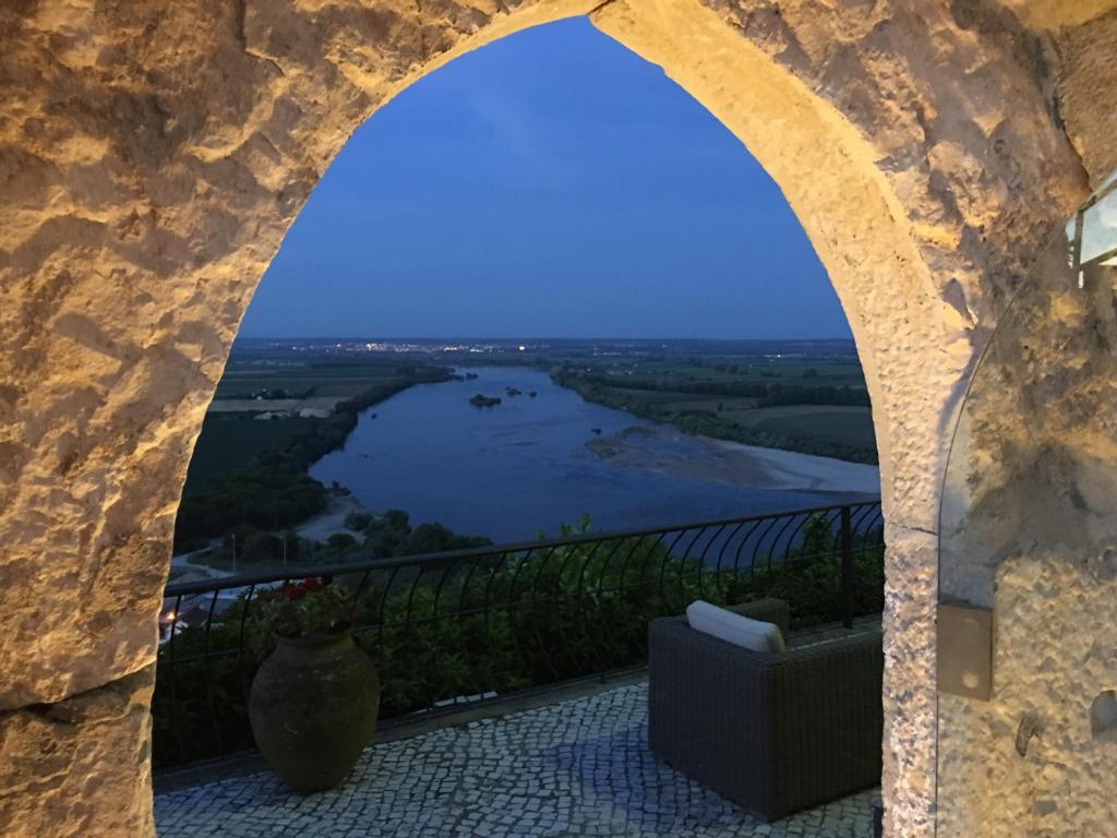 a view of a river through a stone archway at Casa da Alcacova in Santarém