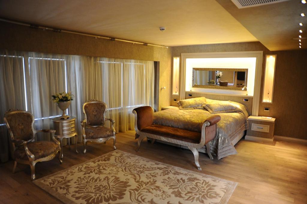 a bedroom with a bed and a chair and a mirror at Limak Eurasia Luxury Hotel in Istanbul