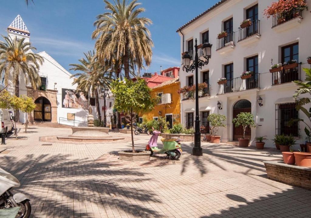 una persona montando un scooter en una calle de una ciudad en Home Away From Home Marbella en Marbella