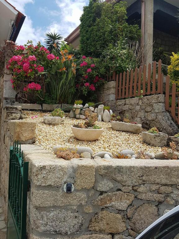 a garden with rocks and flowers in a yard at Casa do Artesanato in Vila Nova de Cerveira