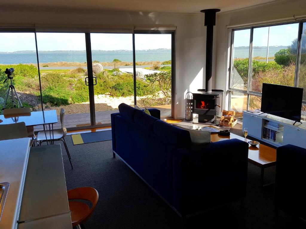 a living room with a couch and a table with a stove at Coorong Waterfront Retreat in Meningie