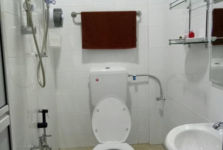 a bathroom with a toilet and a shower and a sink at Sunset Villa Inn in Pantai Cenang