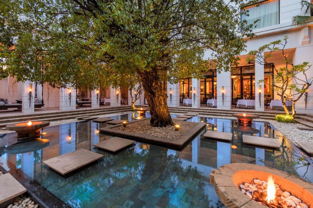暹粒的住宿－柏悅暹粒酒店，一座建筑物中间有树的游泳池