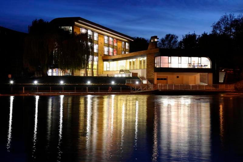 a building next to a body of water at night at Przystan Bydgoszcz in Bydgoszcz