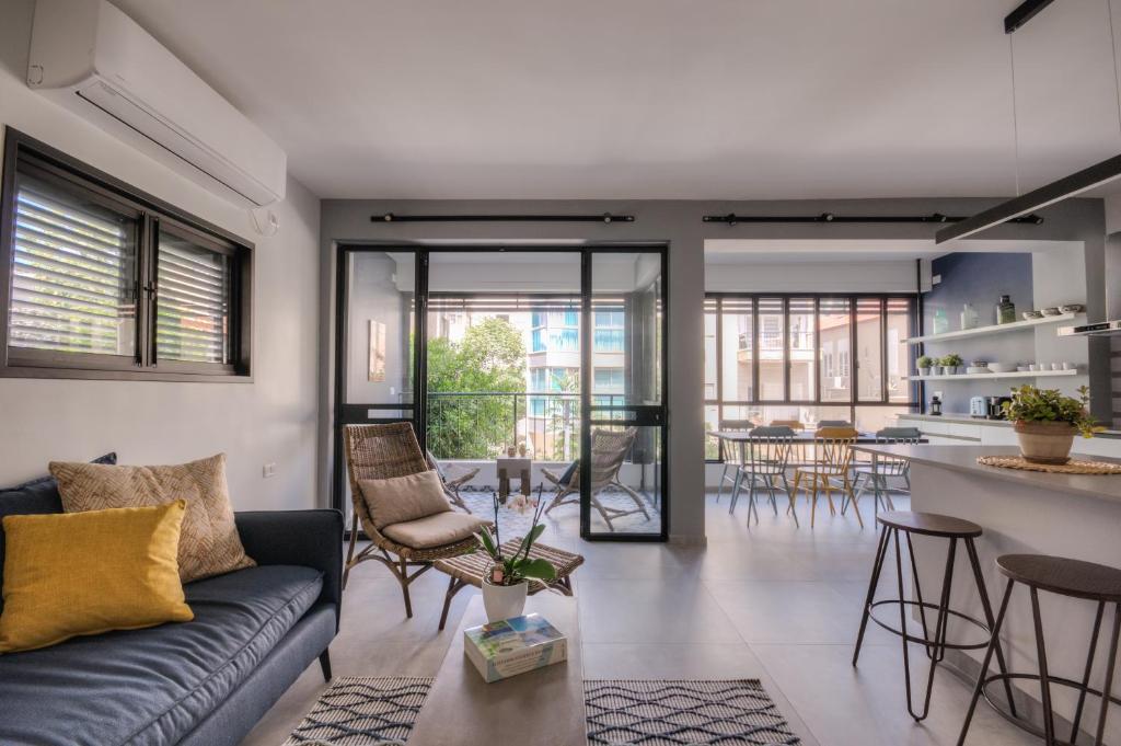 a living room with a couch and a kitchen at Yohanan HaSandlar in Tel Aviv