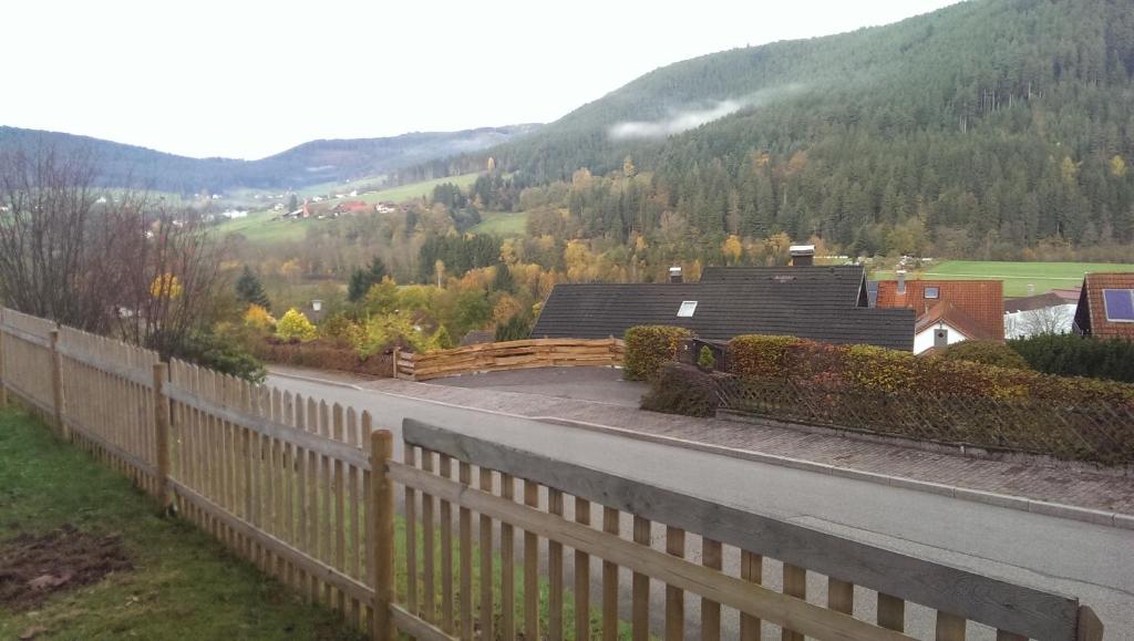 a fence on the side of a road next to a house at Ferien Paradies in Baiersbronn