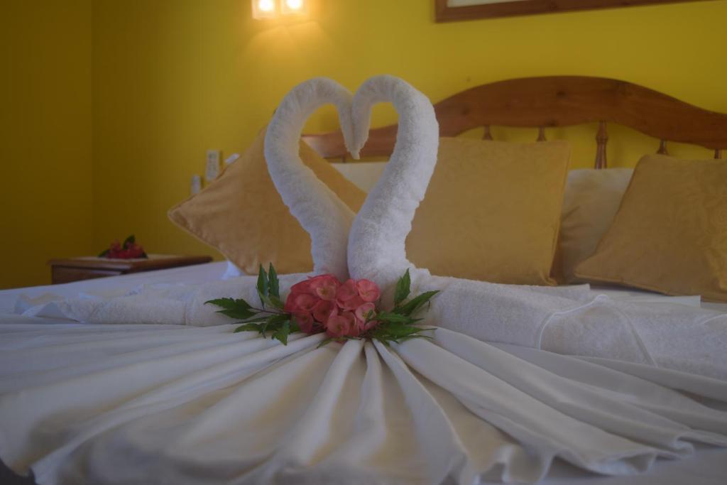 two swans are sitting on top of a bed at Pension Citadelle in La Digue