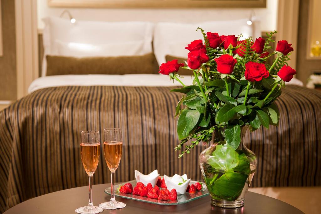 a table with two glasses of champagne and a vase of roses at Limak Eurasia Luxury Hotel in Istanbul
