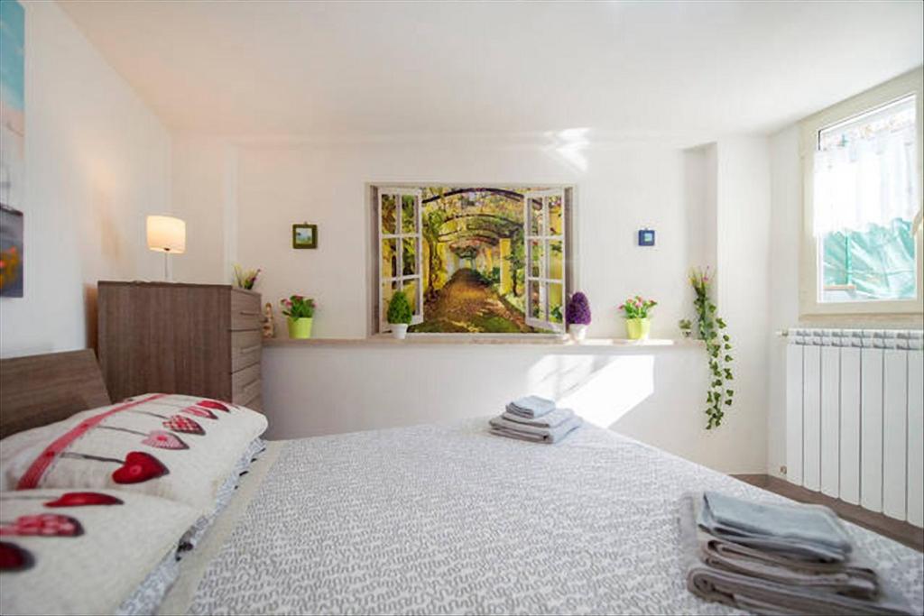 ナポリにあるGARDEN HOUSE Apartments in Naplesのベッドルーム1室(ベッド1台付)が備わります。壁には絵画が飾られています。