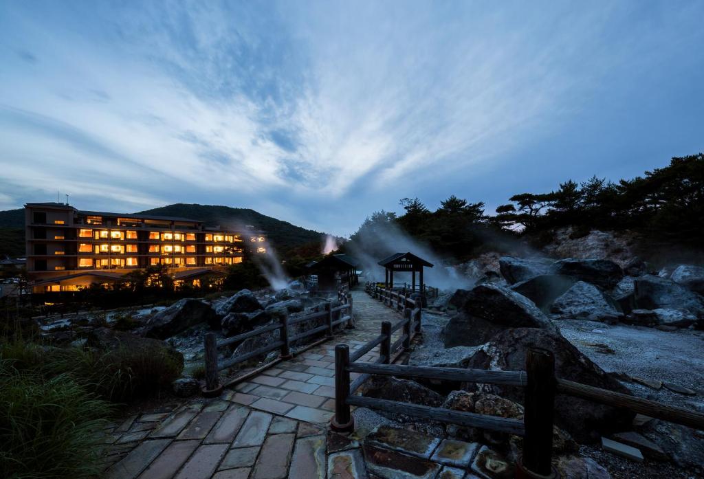 a hotel with a building in the middle of a mountain at Unzen Kyushu Hotel in Unzen