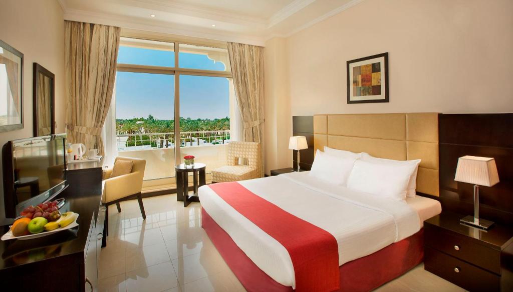 a hotel room with a bed and a balcony at All Seasons Hotel Al Ain - Previously City Seasons in Al Ain