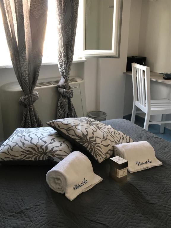 a bedroom with a bed with two pillows and a window at Nereide in Tropea