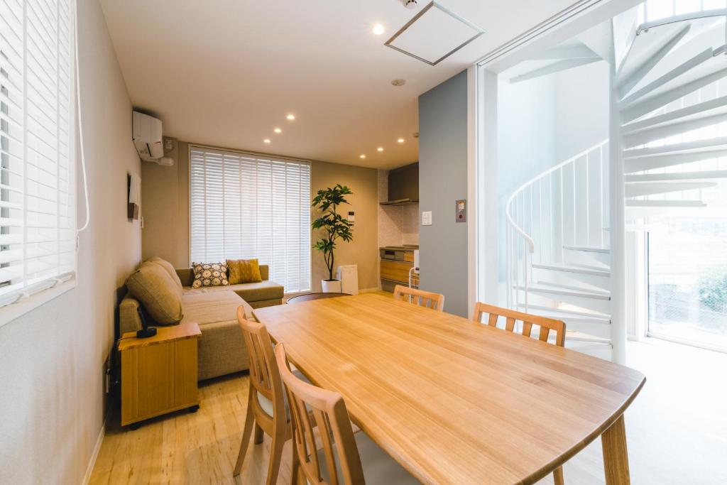 uma cozinha e sala de jantar com uma mesa de madeira e cadeiras em Trip Base HAKATAEKIMAE em Fukuoka