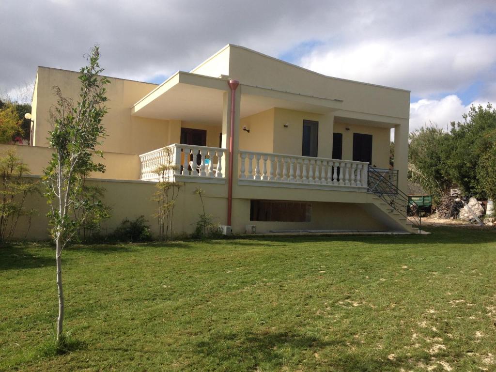 una casa blanca con balcón y patio en Appartamenti Affittacamere Villa Striari, en Otranto
