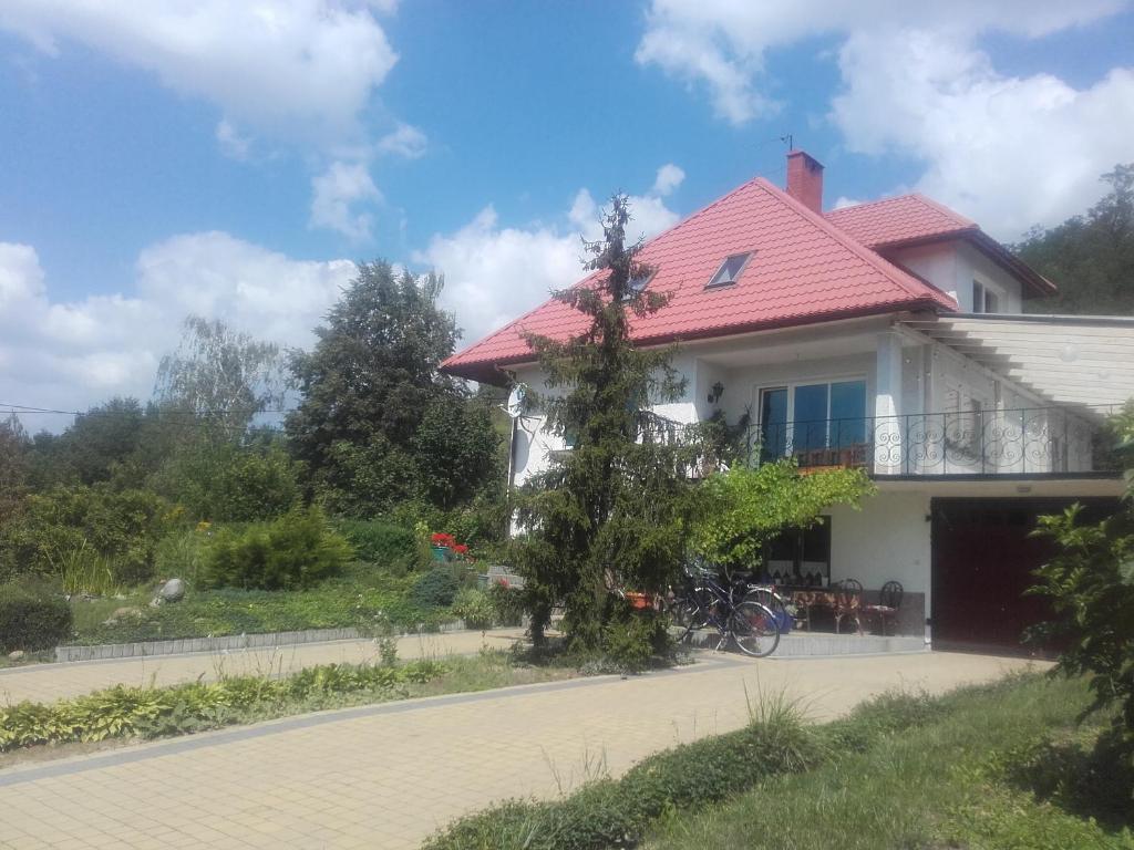 een wit huis met een rood dak op een weg bij Dom w Zielonej Dolinie in Dwikozy