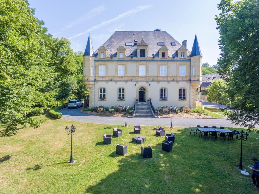 a large house with a picnic table in front of it at Château de Puy Robert LASCAUX - Sarlat in Montignac